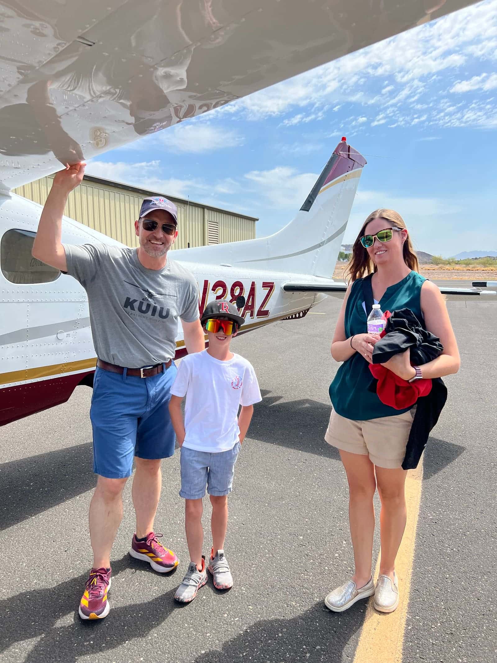 Volunteer pilots and a young passenger after a mission flight