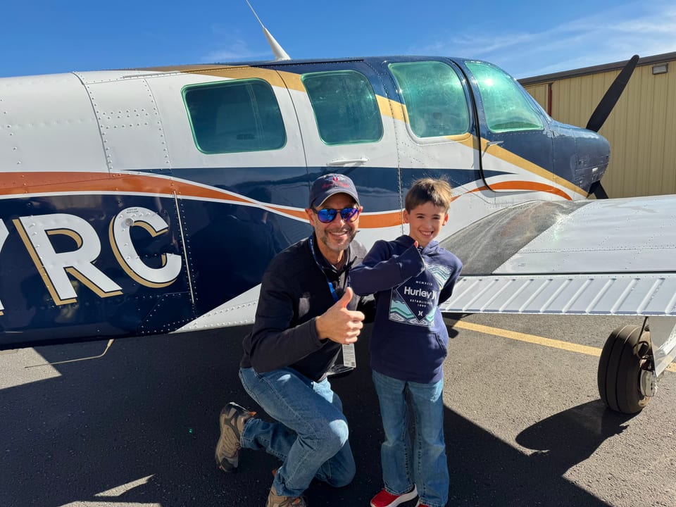 Eli M. and an Angel Flight West volunteer beside an aircraft